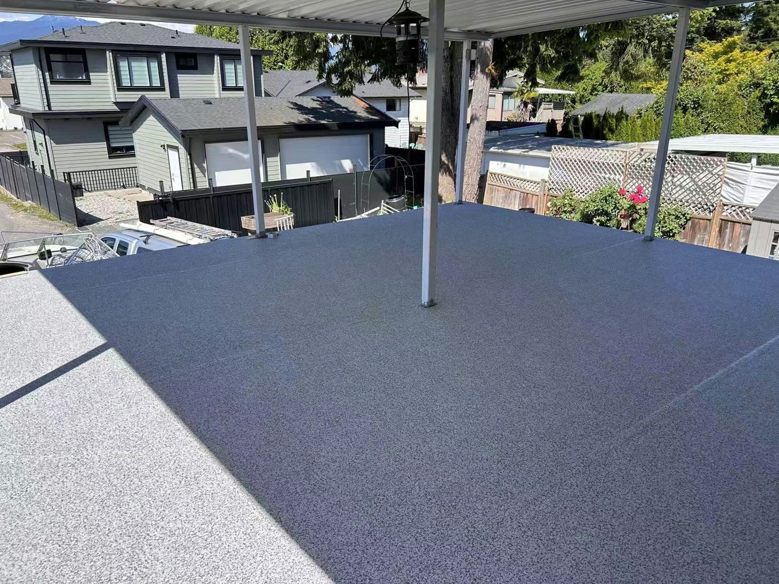 Finished grey vinyl deck under an aluminum patio cover